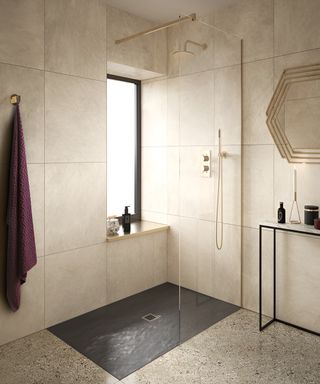 Clear shower screen in front of an open shower with a grey shower floor