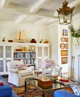 living room with built in shelves and white armchairs