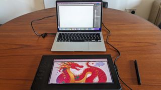 Ugee UE12 Plus review; a drawing table connected to a laptop