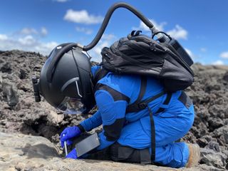 Commander Musilova collecting astrobiological samples during a Marswalk.