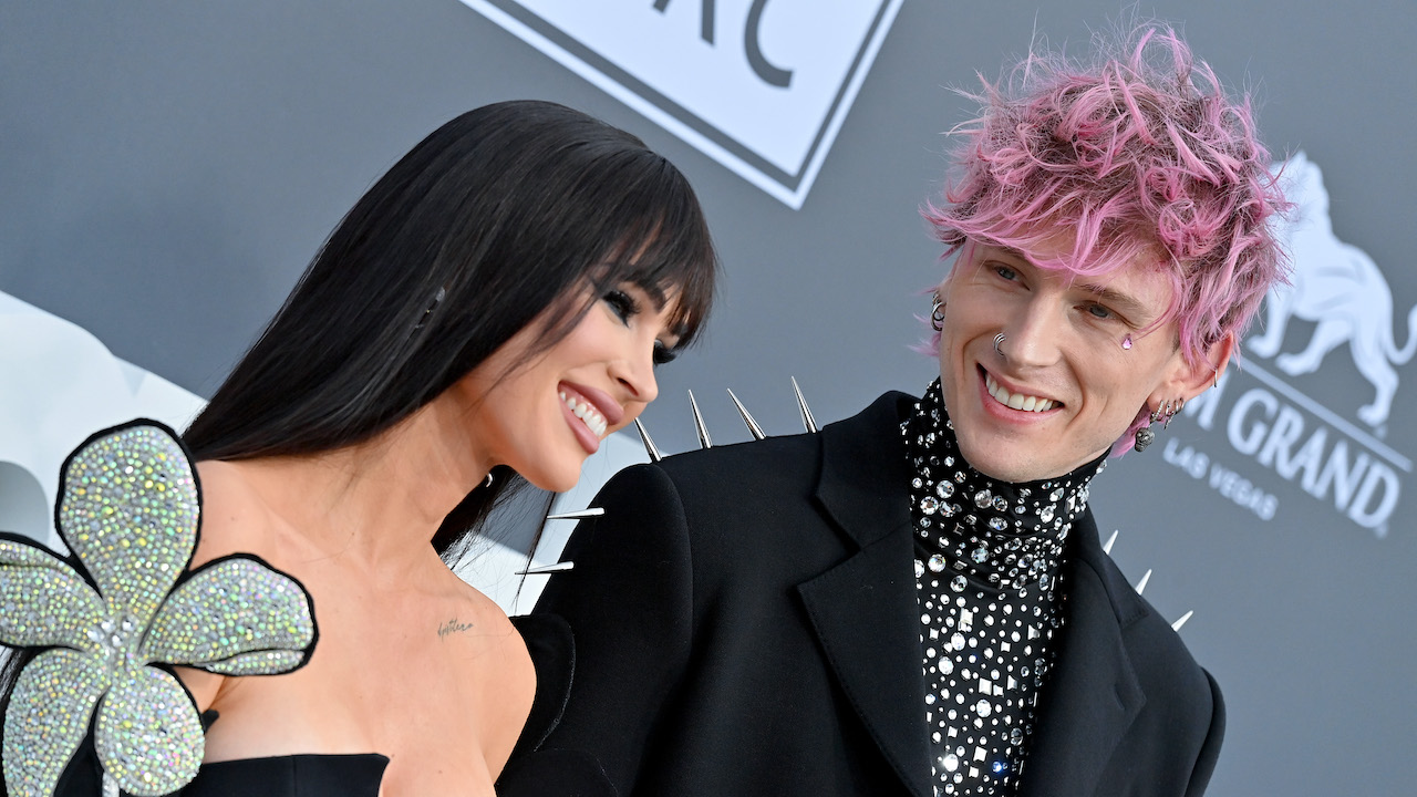 Fox and MGK smiling on the carpet of the 2022 Billboard music awards