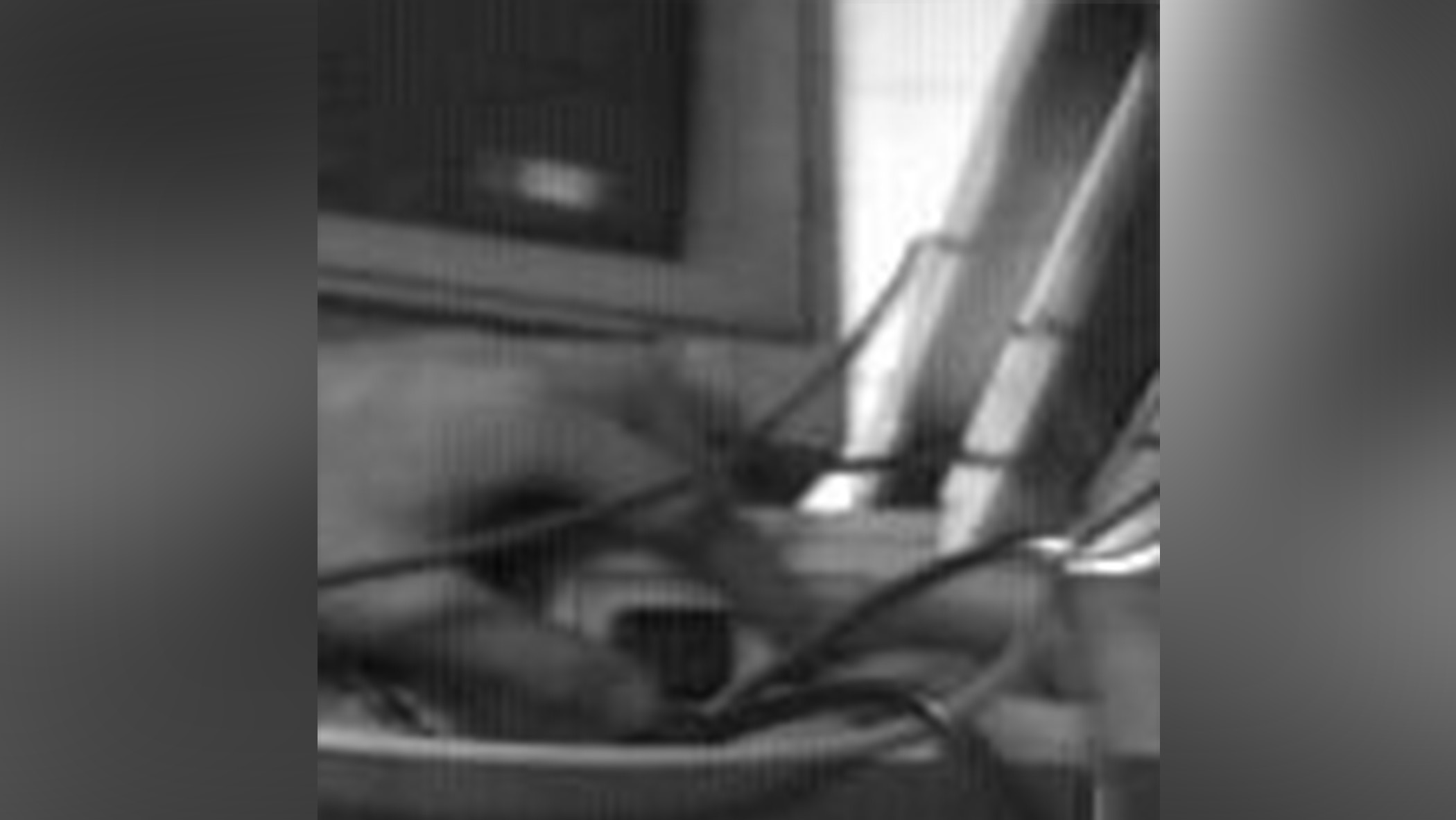 A hand presses a button on a computer.