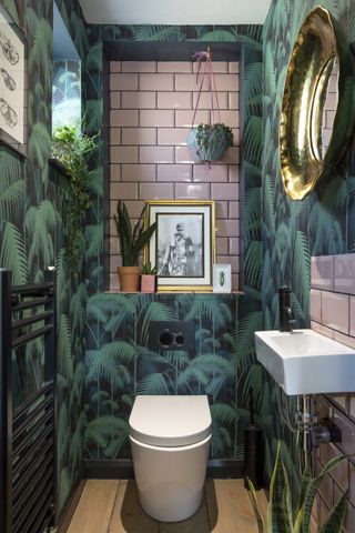 Cloakroom with bold leaf wallpaper and pink tiles