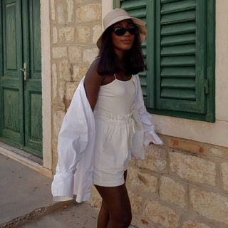 French Girl Holiday Capsule Wardrobe: @aidabadji_ wears a white linen shirt with white shorts