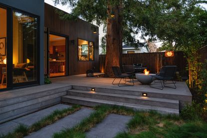 a backyard deck illuminated at night by lighting