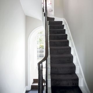 stairs with whitewall and door
