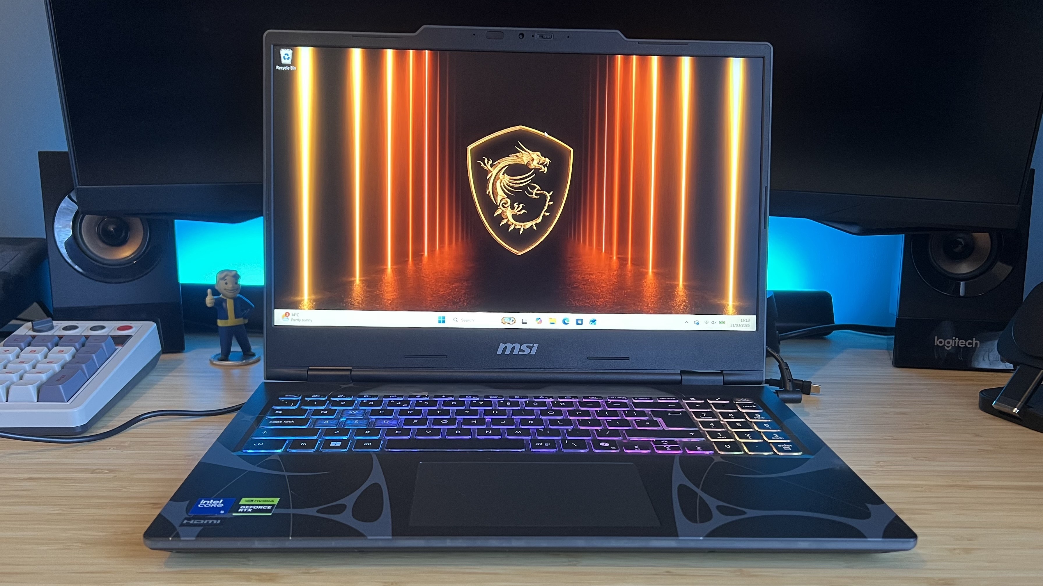 MSI Cyborg gaming laptop on a wooden desk with blue backlighting
