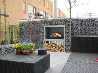 outdoor fireplace in the center of a gabion wall