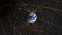 A visualization of Earth surrounded by orange loops that connect to its poles.