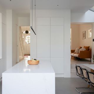 white kitchen cabinets and island on grey floor