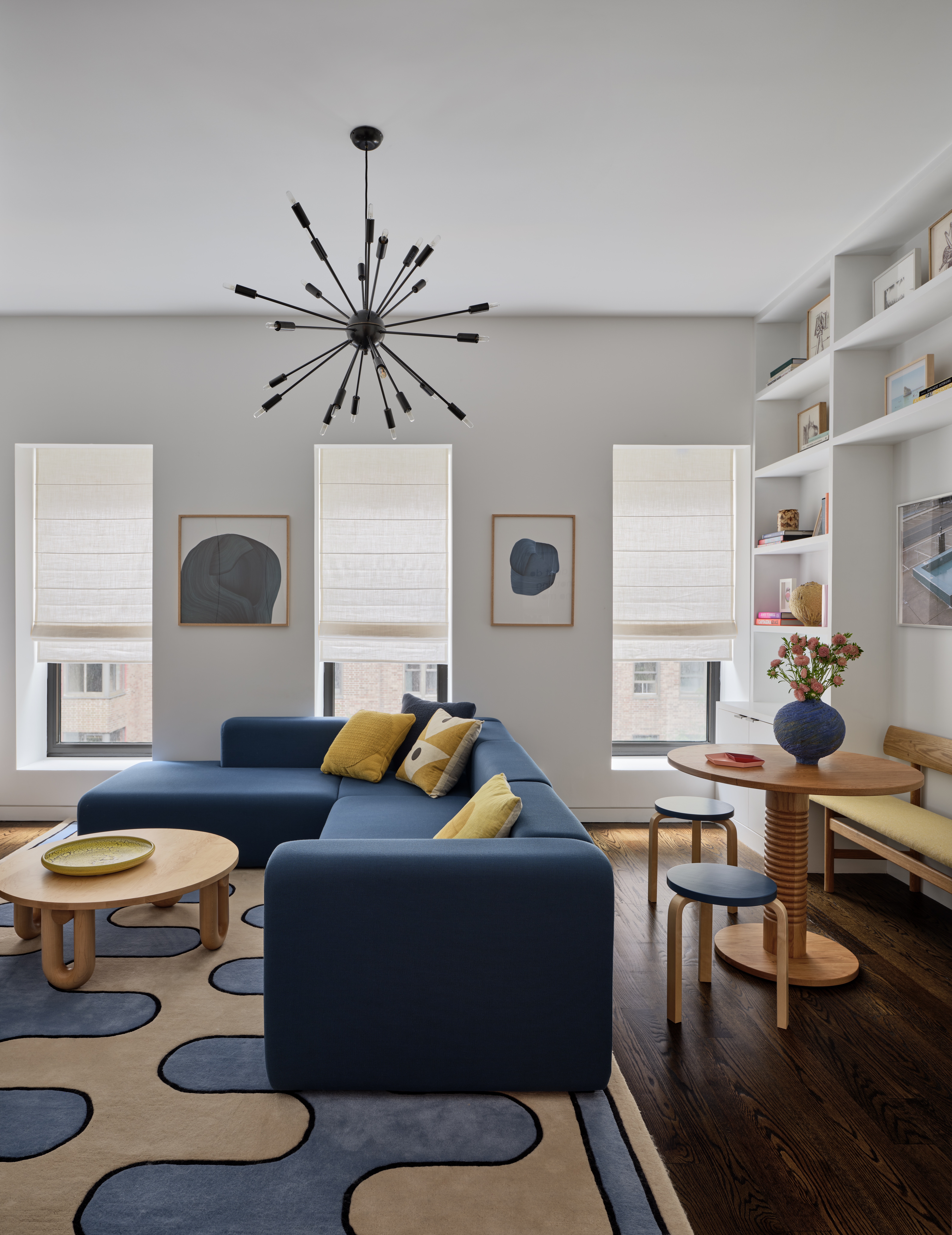 A living room with a graphic pattern rug, a blue sectional