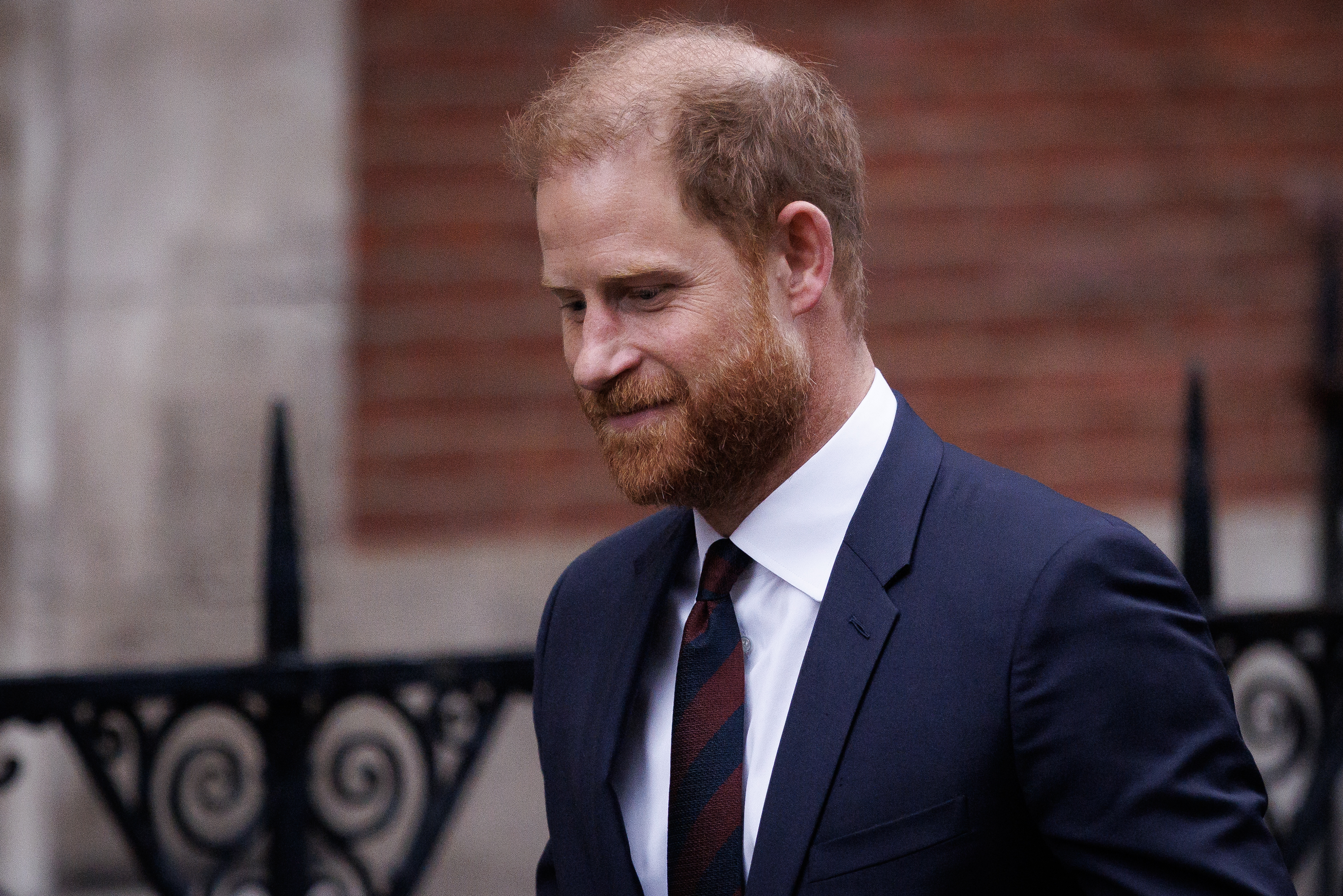 Prince Harry wearing a blue suit and striped tie