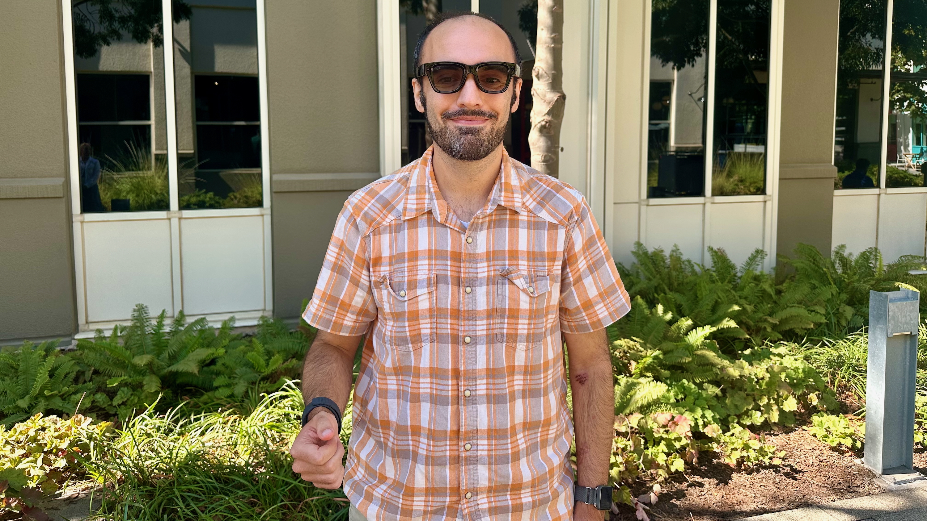 A photo of the author wearing Meta Ray-Ban Display glasses and making a gesture with the sEMG band.