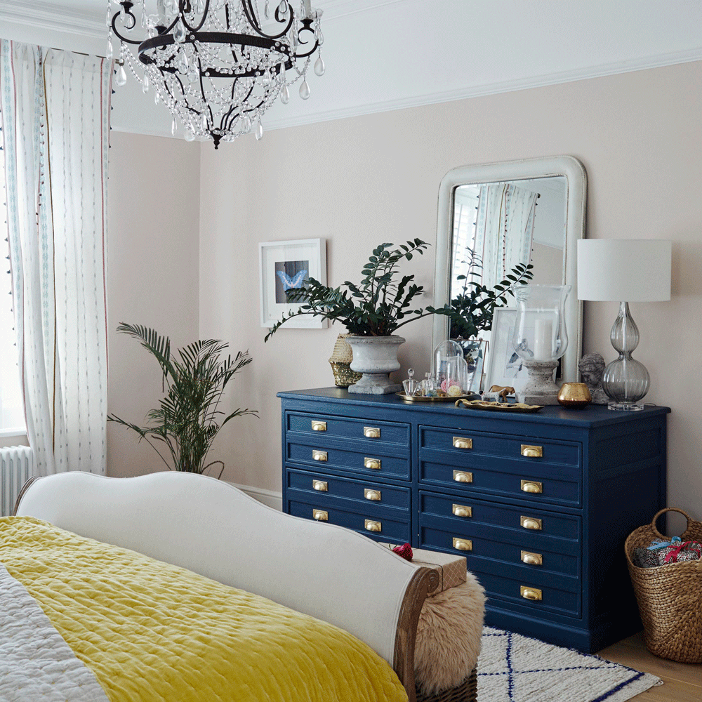 bedroom with white wall and blue sideboard and mirror