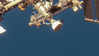 closeup view of a white space capsule docked to the international space station
