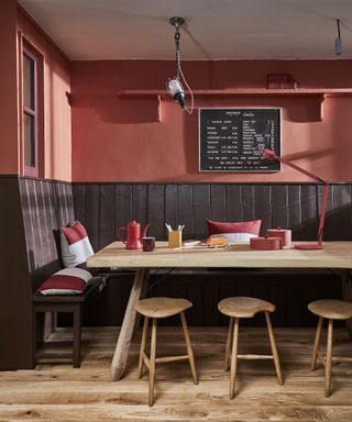 A dining room wall idea with red paint decor and black shiplap wall paneling with peg menuboard