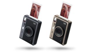 Two Instax Mini Evo cameras, side by side, in Dark Silver and Titanium Gold, against a white background