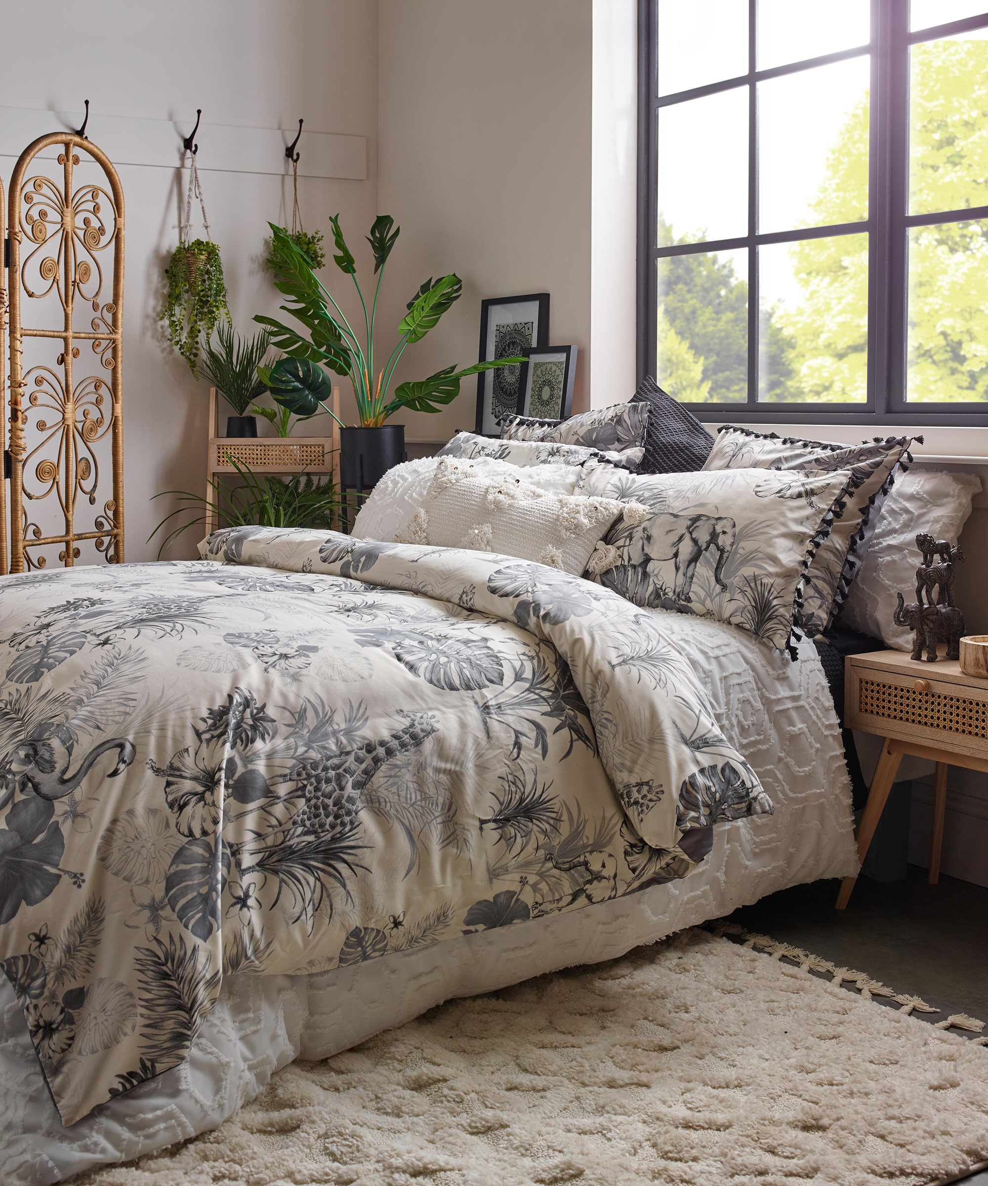 Safari print duvet in bedroom with faux plant corner