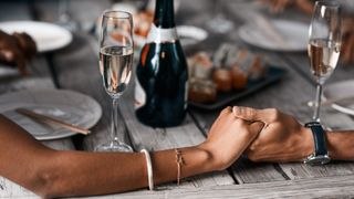 couple holding hands at dinner table