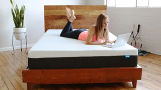 The best Bear mattress deals, featuring a girl laying on a Bear Original mattress
