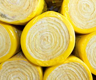 Rolls of Rockwool mineral wool insulation stacked on top of each other with yellow plastic around each one