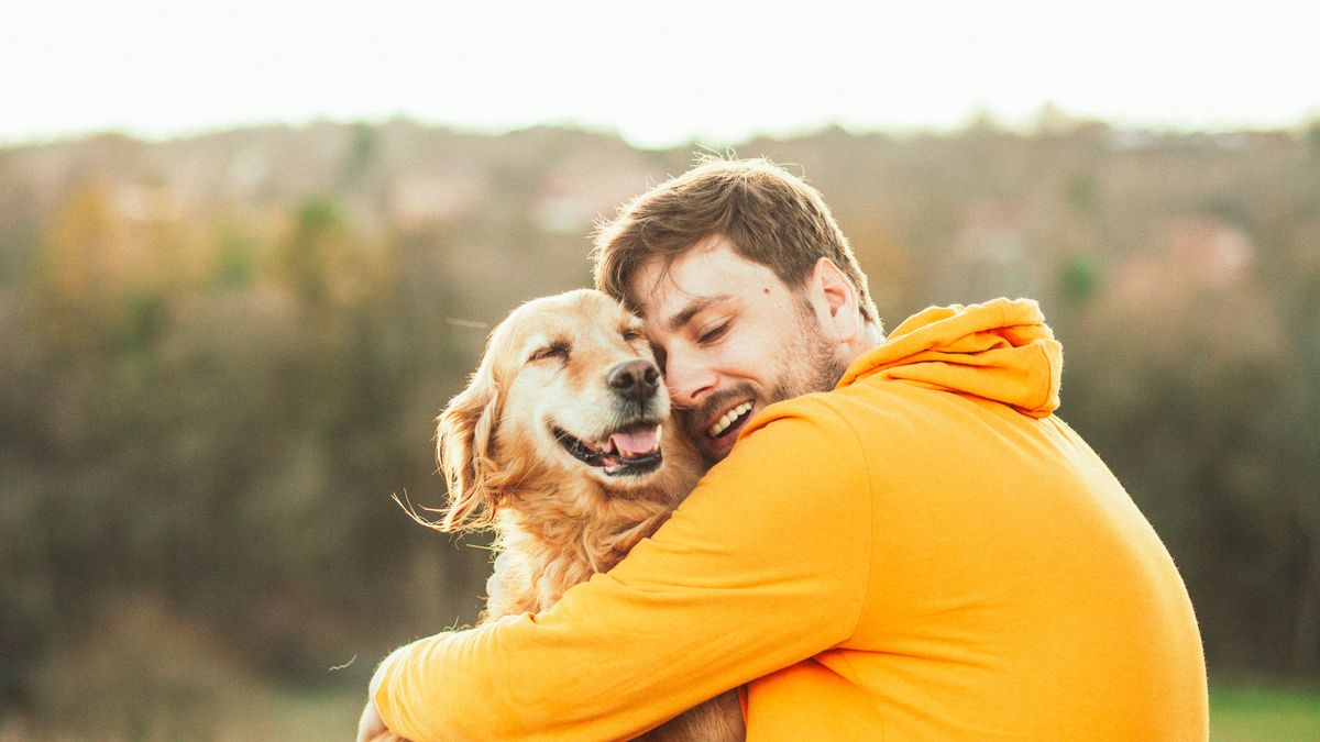 Man hugging his golden retriever