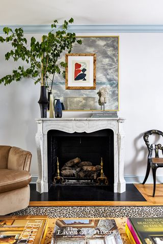 living room fireplace with art above it on blue walls