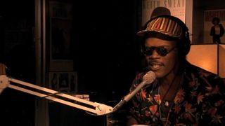 Samuel L. Jackson wearing sunglasses and speaking into a microphone in Do the Right Thing