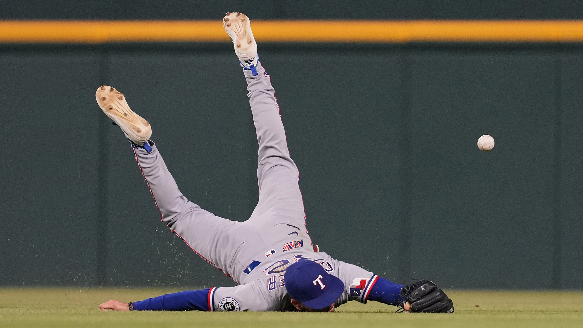 Texas Rangers outfielder Evan Carter dives and misses a fly ball during a baseball game against the Detroit Tigers in Detroit, USA