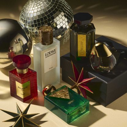 The best fragrance Christmas gifts including Merit Retrospect, Loewe Prado, Balmain Rouge and Hermes Barenia, shot with disco balls