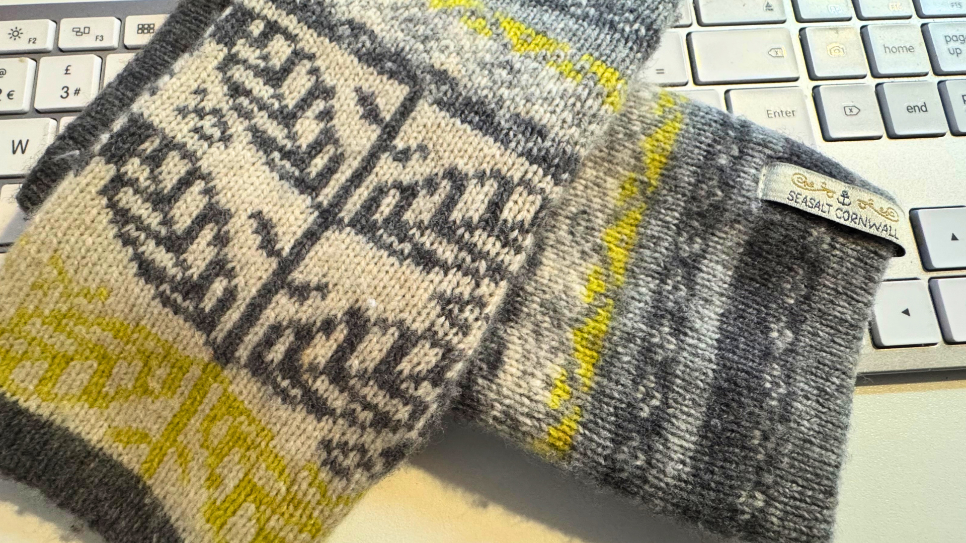 Close-up of Seasalt wrist warmers resting on a keyboard, ideal for staying warm while working from home