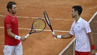 Casper Ruud and Novak Djokovic on the tennis court