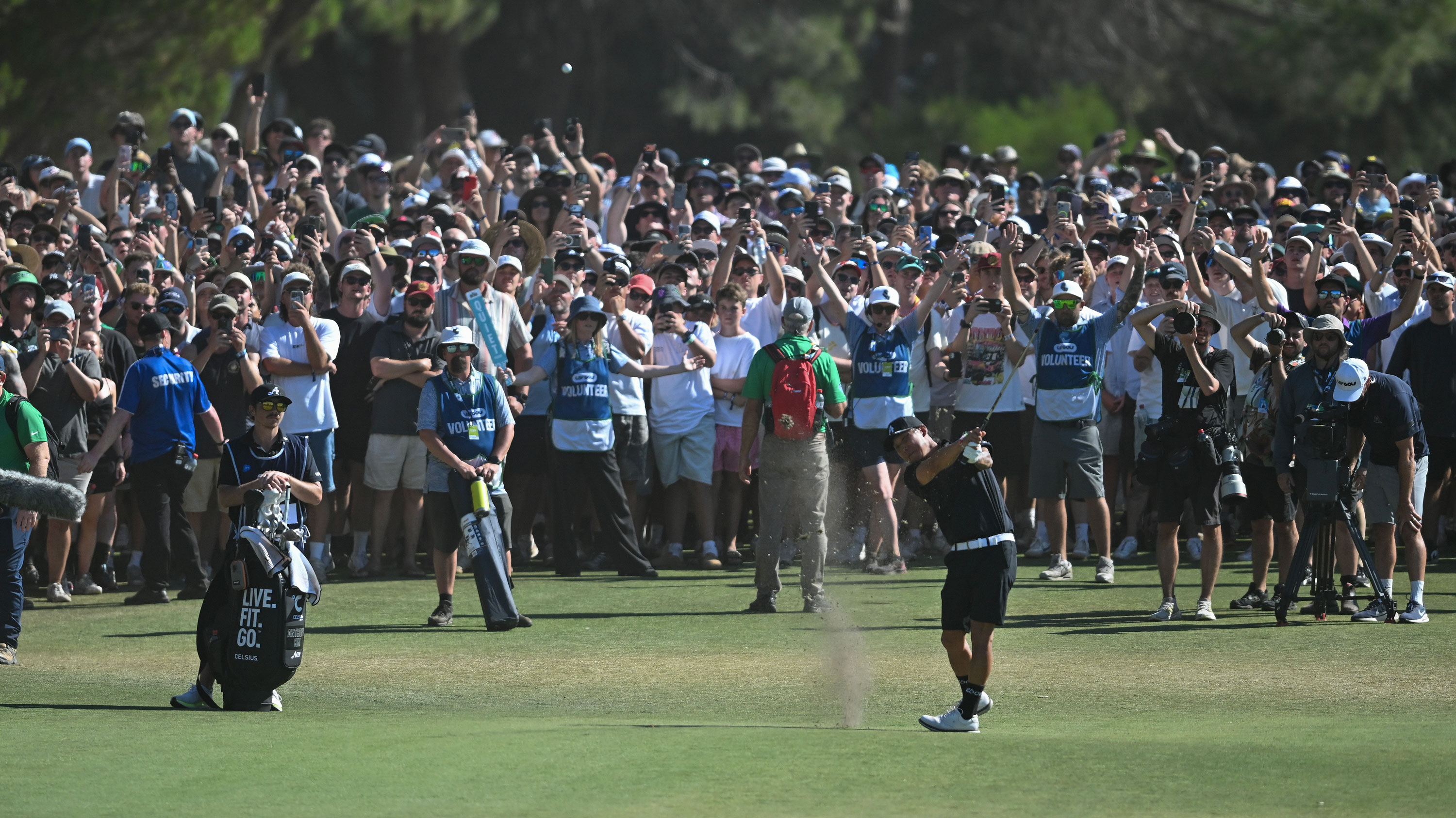 anthony kim hits a shot at liv golf adelaide with a big crowd watching behind