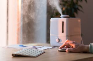 Should you buy a humidifier: Image shows person using a humidifier