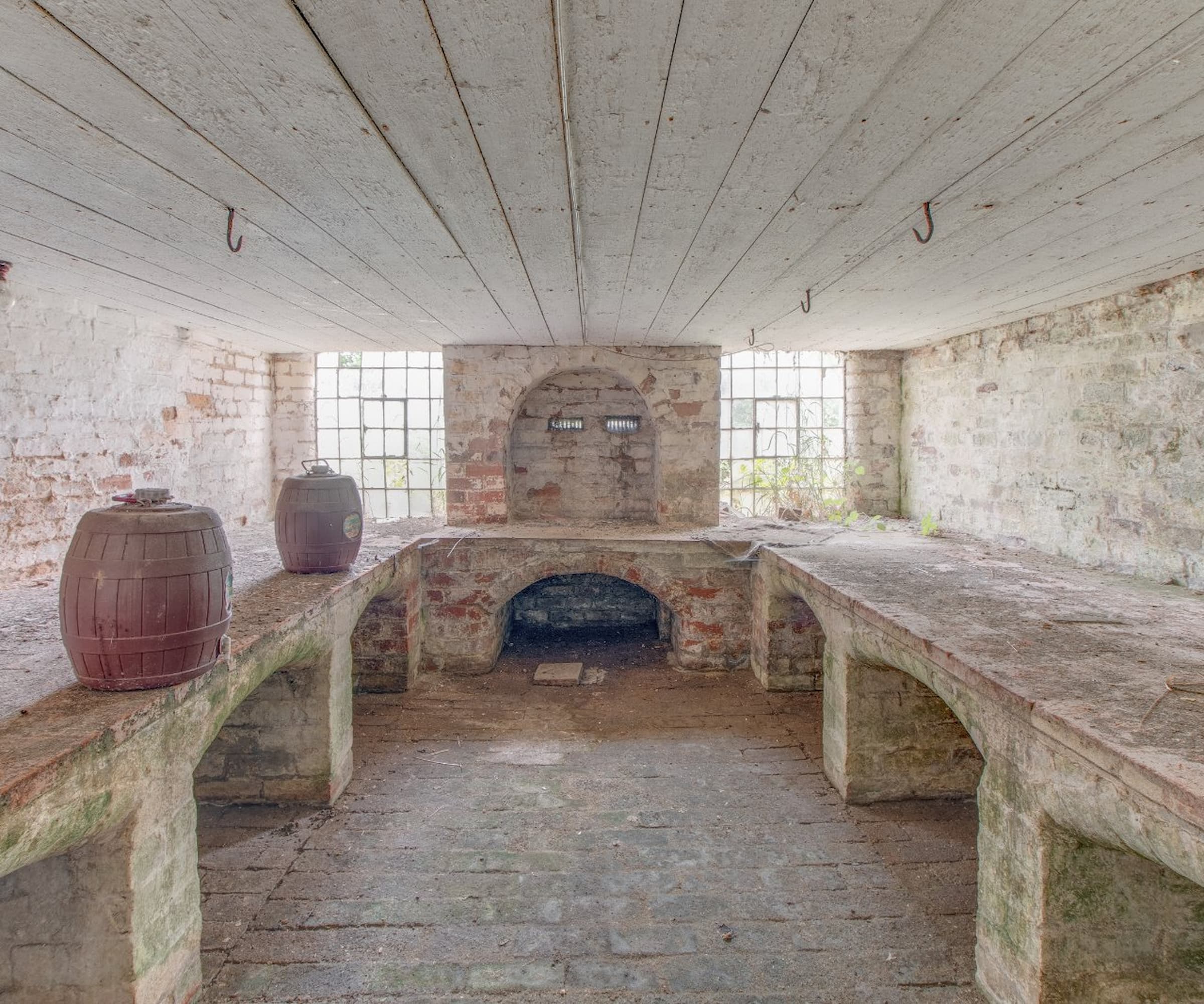 A stone basement used for storing barrels underneath a farmhouse