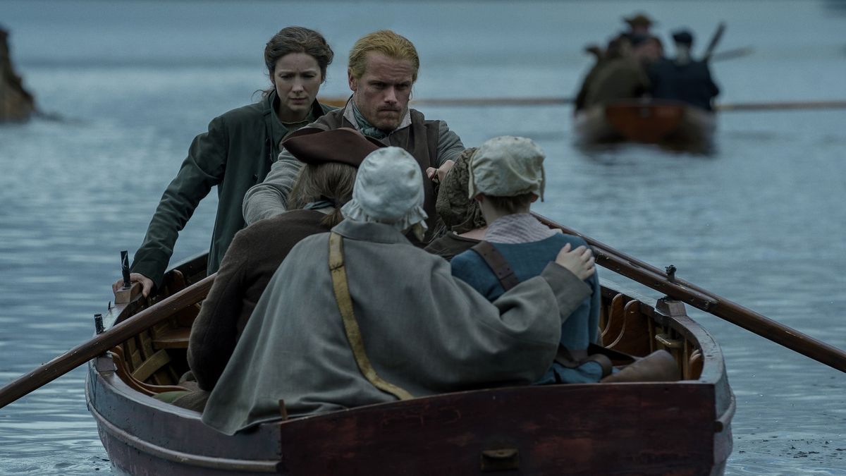 Jamie Fraser rowing a boat with Claire and two other passengers on board in Outlander season 7 episode 6. 