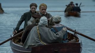 Jamie Fraser rowing a boat with Claire and two other passengers on board in Outlander season 7 episode 6. 