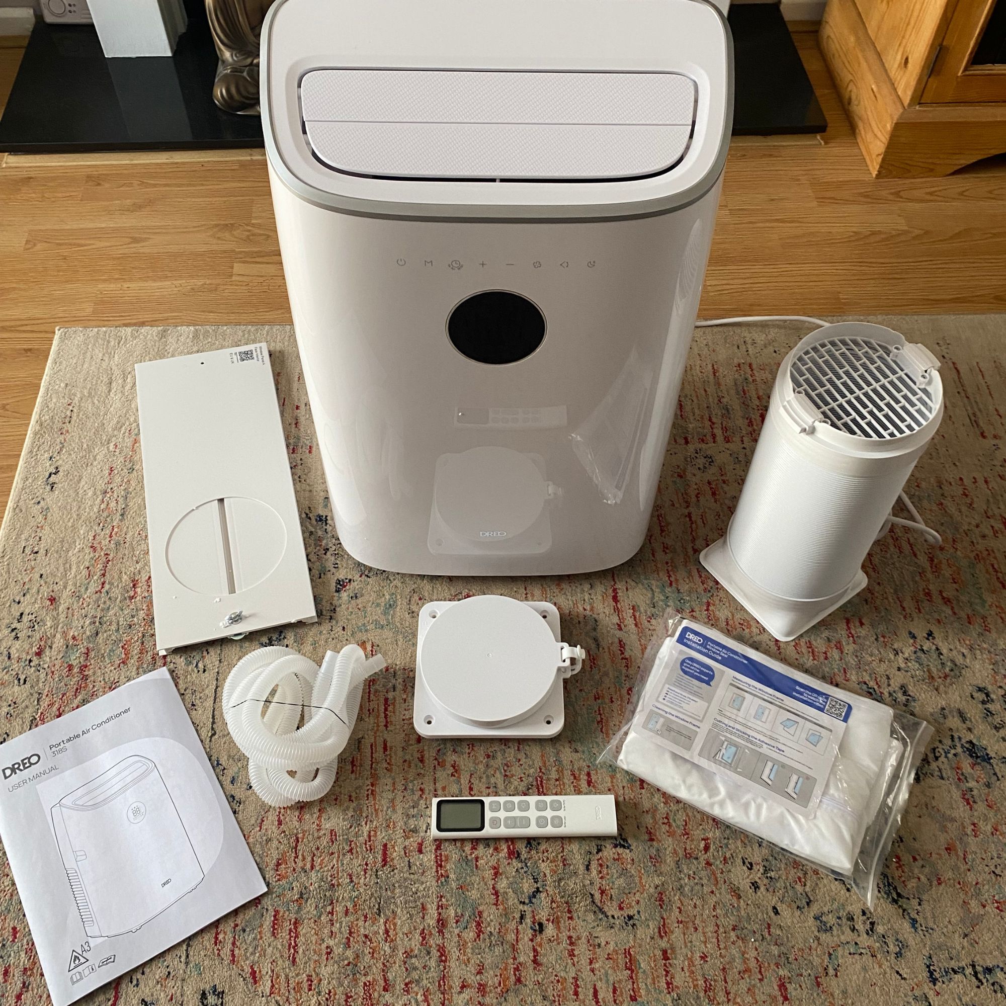 What you get in the box of the Dreo 318s portable air conditioner, including exhaust hose, wall vent kit, window kits, remote, drainage hose, and instructions