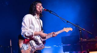 Jessica Dobson of Deep Sea Diver wears a white shirt and plays her Fender Elvis Costello Jazzmaster onstage.