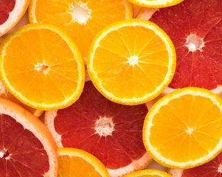 Slices of orange and pink citrus fruits piled together in close focus