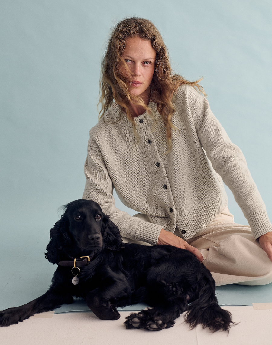a model wearing a cardigan from navygrey next to a black dog