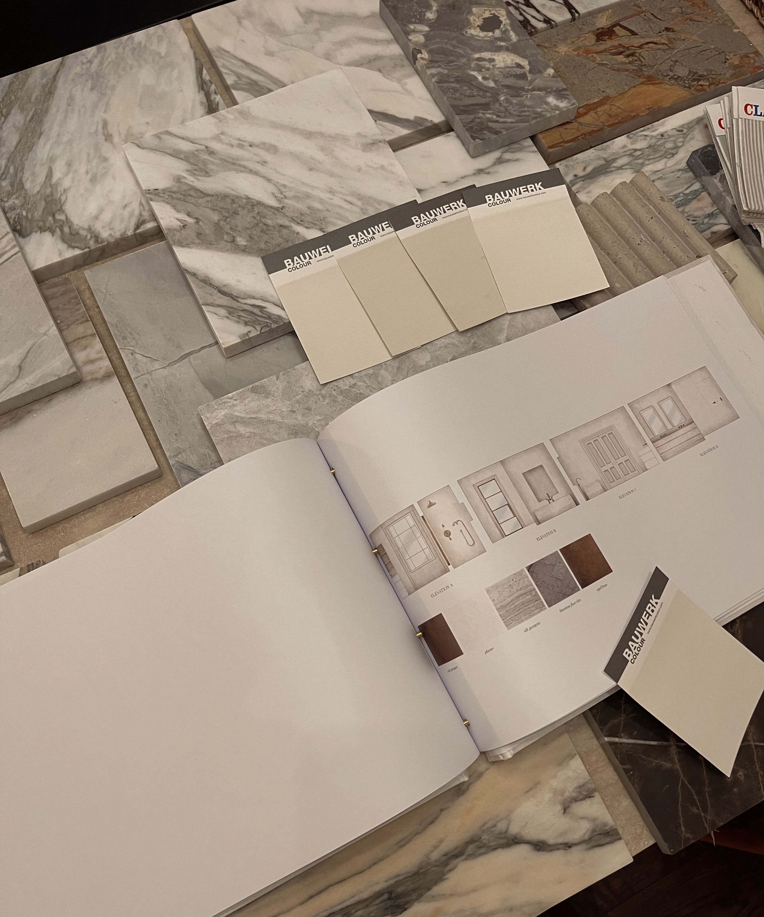 picking samples of white paint laid out with samples of marble