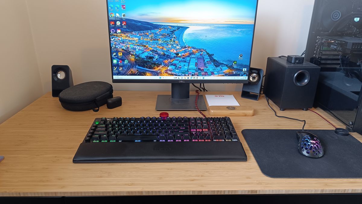 A light-brown FlexiSpot Comhar Pro Q8 standing desk with computer equipment on top of it.