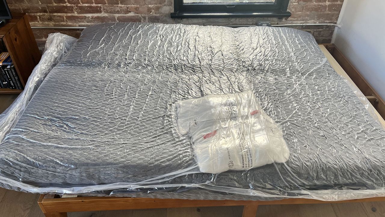 Layla Hybrid mattress in plastic on a bedframe