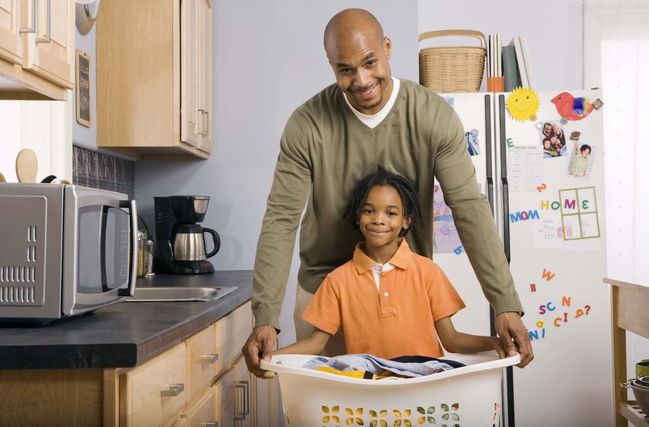 Father and son with laundry basket