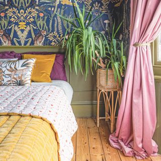 Bright bedroom with wooden floor, jungle wallpaper, and thick pink curtains