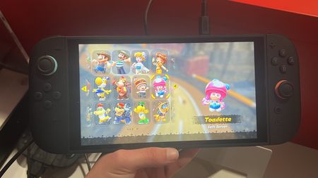 Hand holding Nintendo Switch 2 console playing Mario Kart World