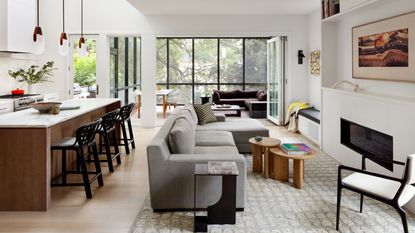 family room with white walls and glass walled extension and gray sofa