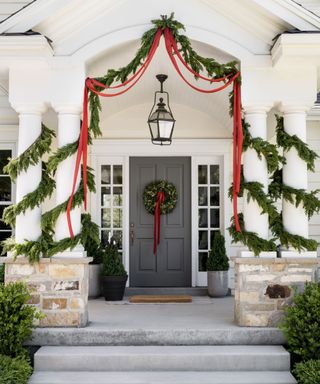 Outside front porch decorated with wreaths, garlands and ribbon