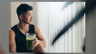 Confident Asian man drinking protein shake after workout. Oscar Wong via Getty Images